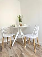 a white table with two chairs and a table with a plant at Logement Entier au Centre Ville in Évreux