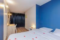 a bedroom with two beds and a blue wall at Spacious and cosy flat in Annecy