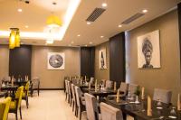 a dining room with black tables and yellow chairs at LAOTEL VIENTIANE in Vientiane