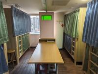 a room with a table and a room with windows at Hey Bear Capsule Hotel in Taipei