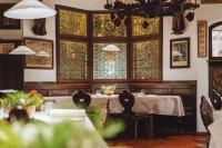 ブレッサノーネにあるADLER Historic Guesthouseのテーブルとステンドグラスの窓が備わるダイニングルーム