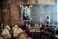 a restaurant with tables and chairs and a mirror at Backstage Boutique SPA Hotel in Zermatt