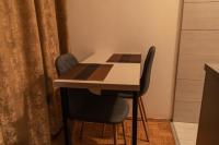 a table and two chairs in a room with a table at Apartman TWO 