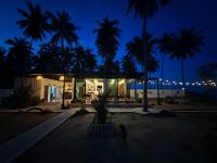 a building with palm trees and lights at night at Chansi Beachresort in Tha Sala