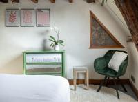 a bedroom with a green chair and a green dresser at Suite Toussaint - Calme &amp; Authentique in Angers