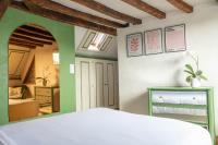 a bedroom with a white bed and a green wall at Suite Toussaint - Calme &amp; Authentique in Angers