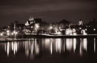 a city at night with lights reflecting in the water at Suite Toussaint - Calme &amp; Authentique in Angers