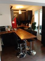 a kitchen with a wooden table and black cabinets at Superb apartment with 108 sq ft terrace in Montreuil