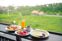 un tavolo con due piatti di prodotti per la colazione e un bicchiere di succo d'arancia di The Pyramid Ubud River Villas a Gianyar