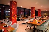 オーク・ブルックにあるLe Méridien Chicago - Oakbrook Centerの木製のテーブルと白い椅子のあるレストラン