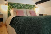 a bedroom with a large green bed with pink pillows at Gîte spa la parenthèse in Sauve
