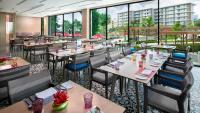 a restaurant with tables and chairs and large windows at Amari Pattaya in Pattaya Central