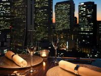 una mesa con copas de vino y vistas a la ciudad en Shinjuku Prince Hotel, en Tokio