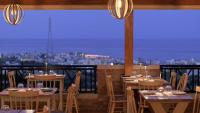 een restaurant met tafels en stoelen en uitzicht op de stad bij Asterias Village in Chersonissos