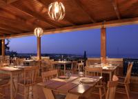een restaurant met tafels en stoelen met uitzicht bij Asterias Village in Chersonissos