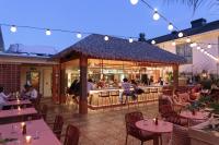 a restaurant with a bar and people sitting at tables at The Ryder Hotel in Charleston