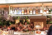 a group of women sitting at a bar with drinks at The Ryder Hotel in Charleston