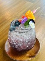 een glazen vaas met bloemen erin op een tafel bij Huather villa & cafe หัวเท่อวิลล่า in Ban Hin Sam Kon