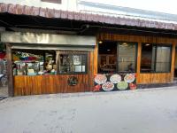 ein Geschäft vor einem Restaurant mit Schildern am Fenster in der Unterkunft Twin Palms Hostel Phi Phi in Ko Phi Phi