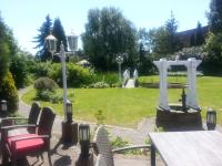 a garden with a picnic table and white gates at Hotel Specht in Witten
