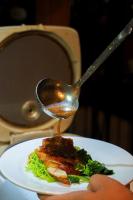 une cuillère avec de la sauce sur une assiette de nourriture dans l'établissement Bangkok Palace Hotel, à Bangkok