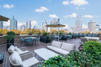 a rooftop patio with chairs and tables and a city skyline at SSAW Boutique Hotel Shanghai Bund in Shanghai