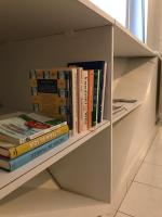 a book shelf with a bunch of books on it at L&#39;ARCADIANE - Studio - Face aux Thermes - Centre Ville in Vichy