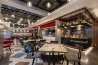 a restaurant with tables and chairs and a bar at Hotel Indigo Kuala Lumpur on the Park by IHG in Kuala Lumpur