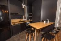 a kitchen with a wooden table and some bar stools at T3quartier Rsidentielcosyfamilleamis in Mâcon