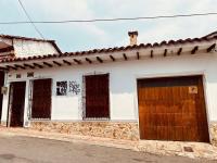 un edificio blanco con una puerta y ventanas marrones en Hostal Patio del Río, en Cali