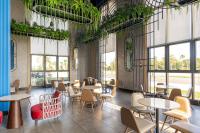 een restaurant met tafels, stoelen en ramen bij K-Town Resort Phan Thiet in Phan Thiet