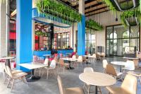 een restaurant met tafels, stoelen en planten bij K-Town Resort Phan Thiet in Phan Thiet