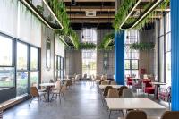 een eetkamer met tafels en stoelen en ramen bij K-Town Resort Phan Thiet in Phan Thiet