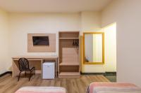 a room with two beds and a desk and a mirror at DELPLAZA Timbiras São Paulo in São Paulo