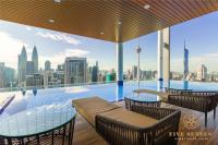 Una piscina con mesas y sillas y un horizonte de la ciudad. en The Colony &amp; The Luxe Signature Suites, KLCC, en Kuala Lumpur