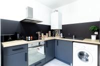 a kitchen with blue cabinets and a washing machine at Grand &amp; Lumineux T2 au Coeur de Monplaisir • Métro à 2’ • Parking Privé in Lyon