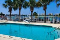 einen Pool mit Palmen und einem Zaun in der Unterkunft Barataria 204 in Destin