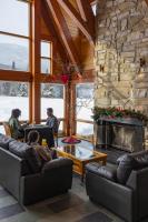 a living room with couches and a stone fireplace at Gîte du Mont-Albert - Sepaq in Sainte-Anne-des-Monts