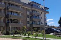un edificio con un coche aparcado delante en Dpto. nuevo una cuadra del lago., en Villarrica