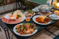 een tafel met veel borden eten erop bij แคมป์ต๊ะต่อนยอน แม่กำปอง เชียงใหม่ CAMP Ta-Torn-Yorn Maekampong Chiang Mai in Mae On