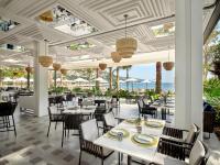 een restaurant met witte tafels en stoelen en de oceaan bij Caja by Maxx Royal in Bodrum City