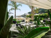 een patio met tafels en stoelen en uitzicht op het strand bij Caja by Maxx Royal in Bodrum City