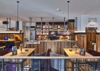 ノルトホルンにあるHotel-Hofbräu am Stadtringの木製のテーブルとバーのあるレストラン