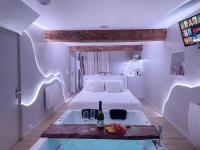 a bedroom with a bed and a table with wine glasses at À la folie - Loft &amp; Spa in Montrevault