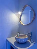 a blue bathroom with a sink with a mirror at À la folie - Loft &amp; Spa in Montrevault