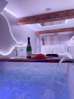a swimming pool with a bottle of beer and wine glasses at À la folie - Loft &amp; Spa in Montrevault