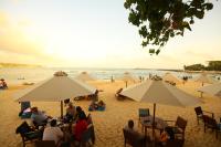 a group of people sitting under umbrellas on a beach at Kingfisher in Unawatuna