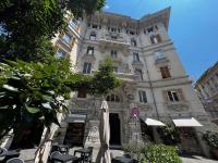 a building with chairs and umbrellas in front of it at Hotel Genova Liberty in Genoa