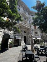 a building with tables and chairs in front of it at Hotel Genova Liberty in Genoa
