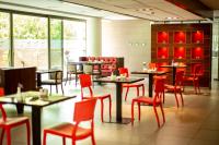 Un comedor con mesas y sillas rojas. en abba Presidente Suites Santiago, en Santiago